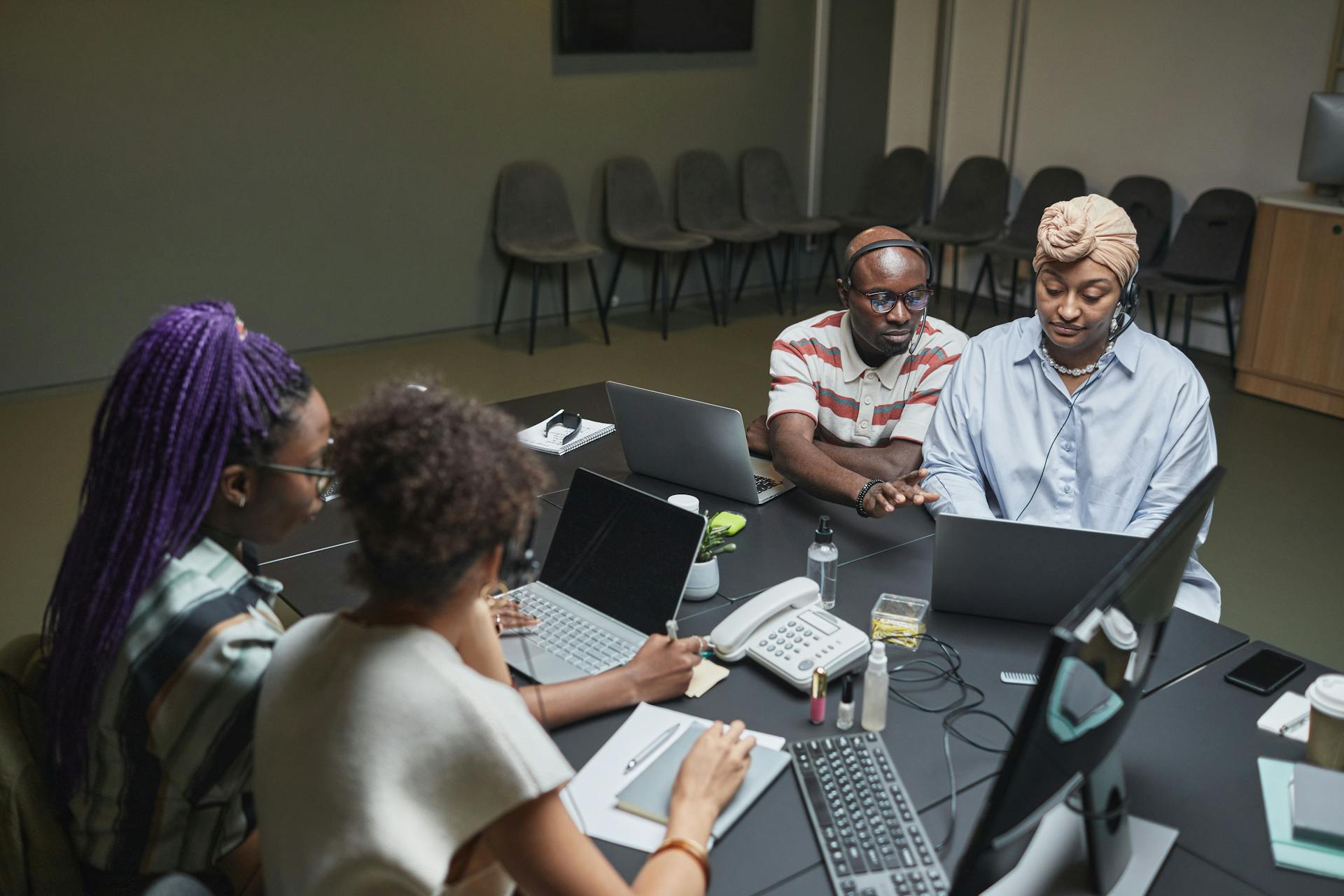 A focused team working with laptops and documents at an office table, demonstrating teamwork and diversity.