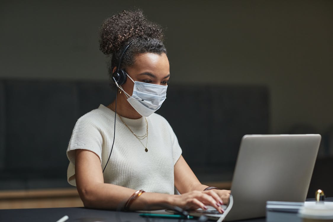 Woman with Headphones Using a Laptop