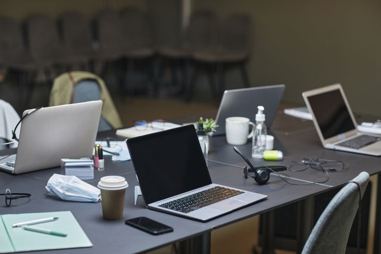 Laptops and notes left on a meeting-room table — photo by Jep Gambardella on Pexels