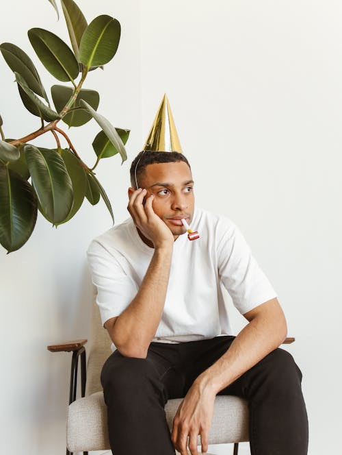 Free A Lonely Man Wearing a Party Hat  Stock Photo