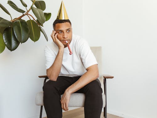 Free A Lonely Man Wearing a Party Hat Stock Photo