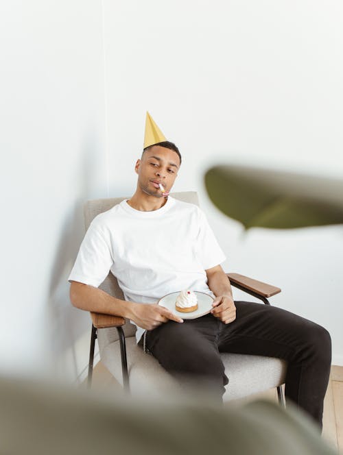 A Man Sitting Wearing Party Hat