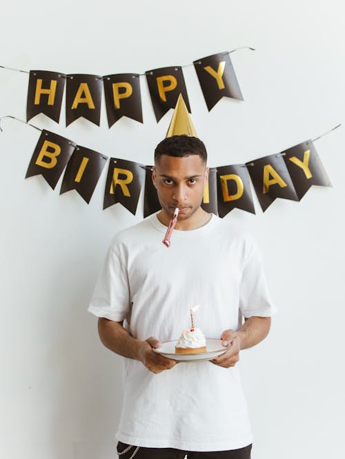 Man Holding a Plate with Cupcake Celebrating Birthday Alone