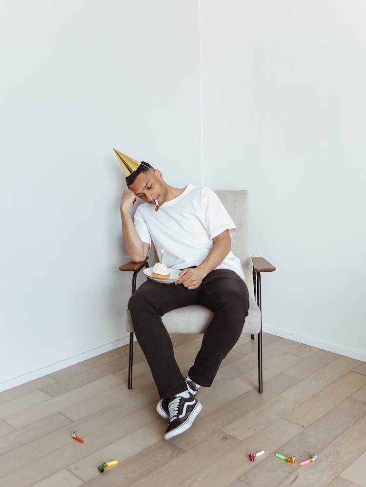 Man Sitting On A Chair With A Cake Celebrating Birthday Alone