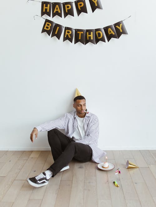 Free Man with Party Hat Celebrating Birthday Alone Stock Photo