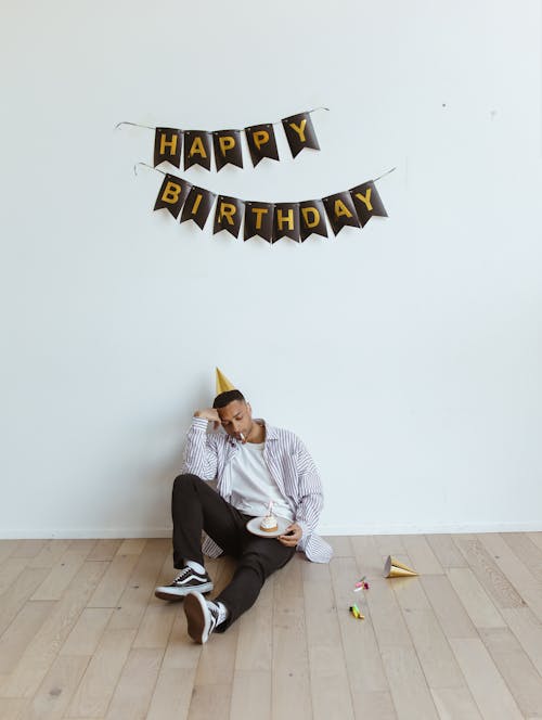 Free A Man with a Party Hat Sitting on the Floor Stock Photo