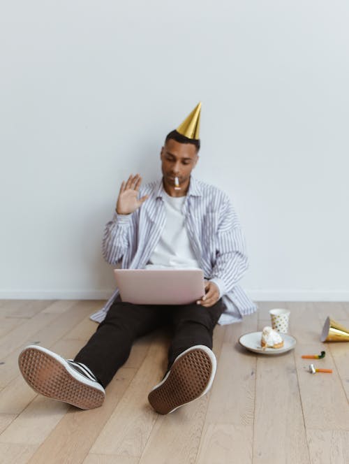 Free A Man with a Party Hat Sitting on the Floor Stock Photo