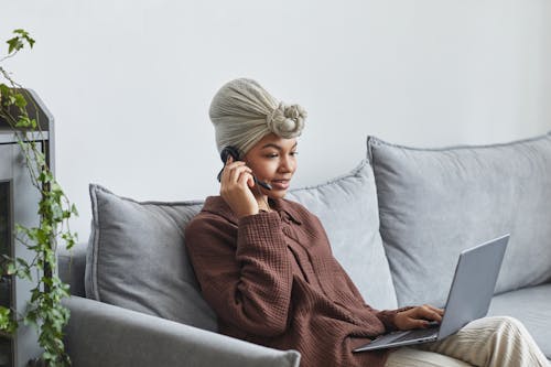 Black woman with headset browsing laptop