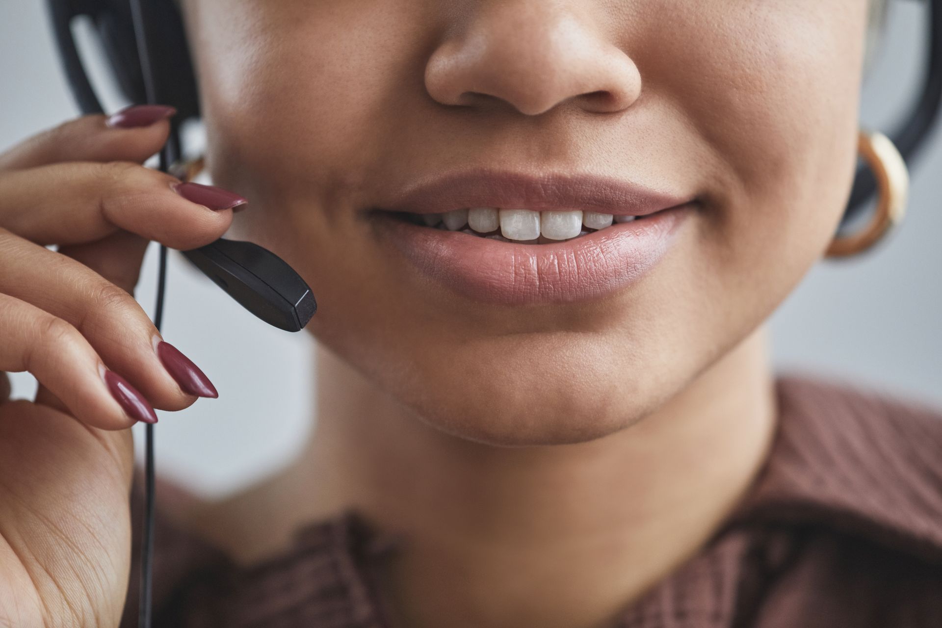 Friendly close-up of a woman with a headset at a call center, showcasing professional demeanor.