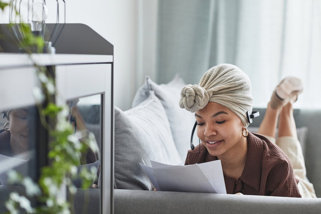 Content black woman with headset reading documents