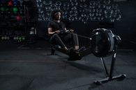 Man in Black Activewear Using a Rowing Machine