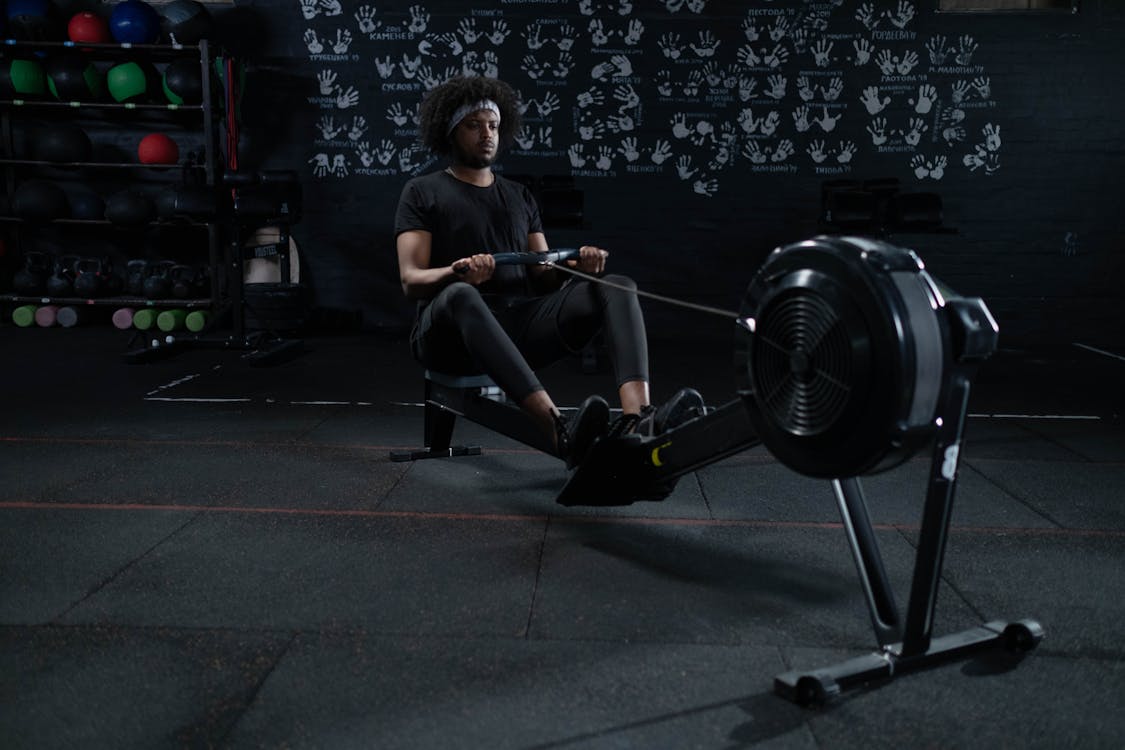 Man in Black Activewear Using a Rowing Machine · Free Stock Photo