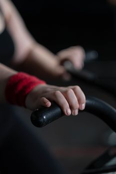 Close-up image of a hand gripping an exercise bike handle, focusing on fitness effort.