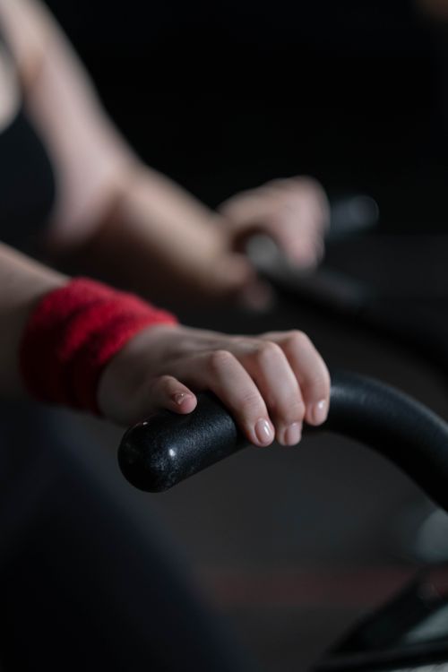 Free Close-up image of a hand gripping an exercise bike handle, focusing on fitness effort. Stock Photo