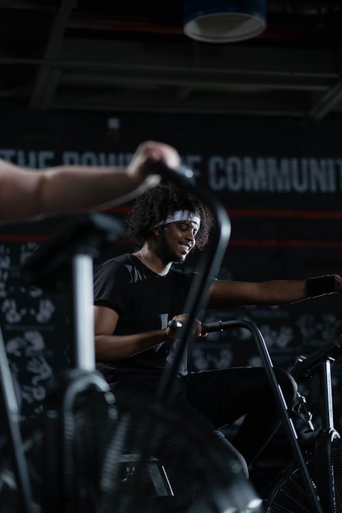 Man in Black Activewear Using a Stationary Bicycle