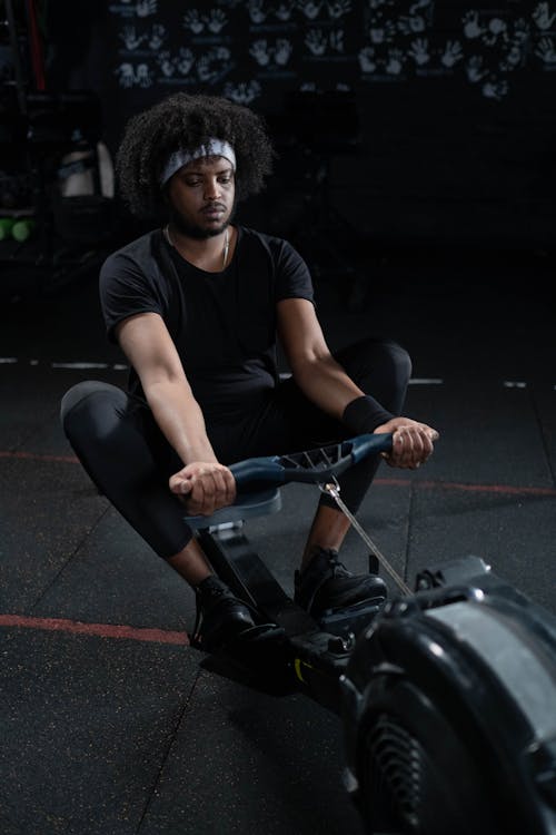 Man in Black Activewear Using a Rowing Machine