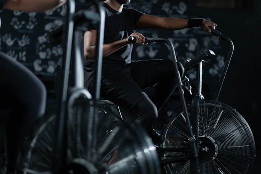 A person engaged in an intense indoor cycling workout on a stationary exercise bike, promoting fitness and healthy living.