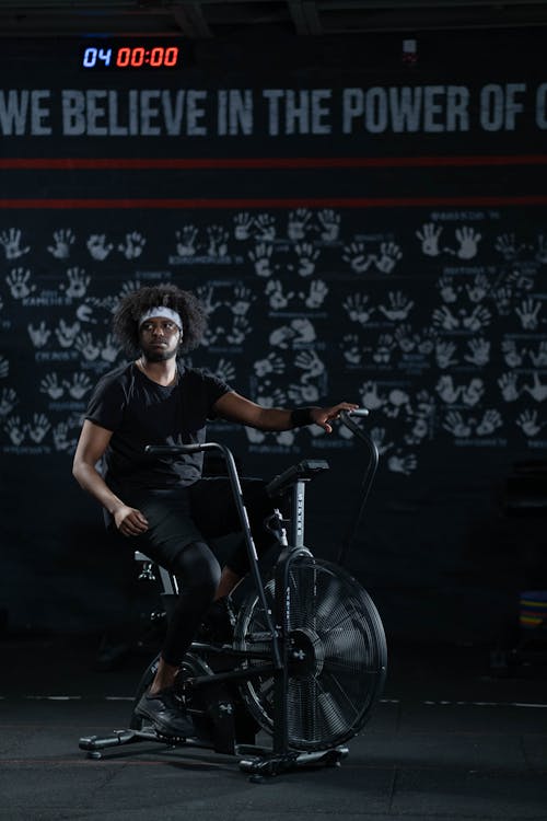 Free Man in Black Activewear Using a Stationary Bicycle Stock Photo