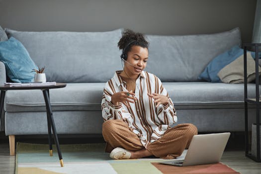 African American woman in casual home setting having a remote work video call on her laptop.