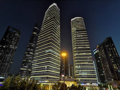 Night view of Shanghai's illuminated skyscrapers showcasing modern urban architecture.