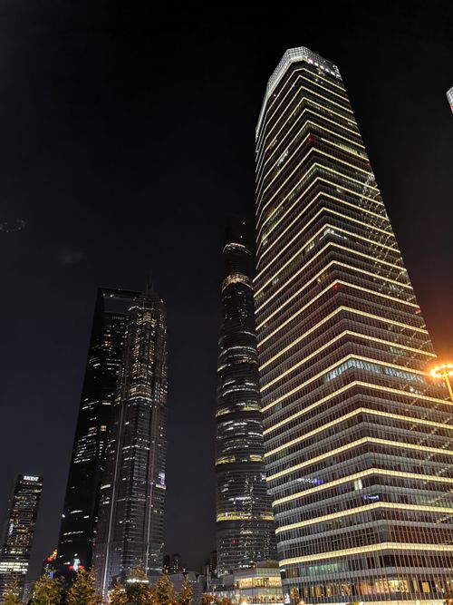 Free Nighttime view of towering skyscrapers with illuminated windows in modern urban cityscape. Stock Photo