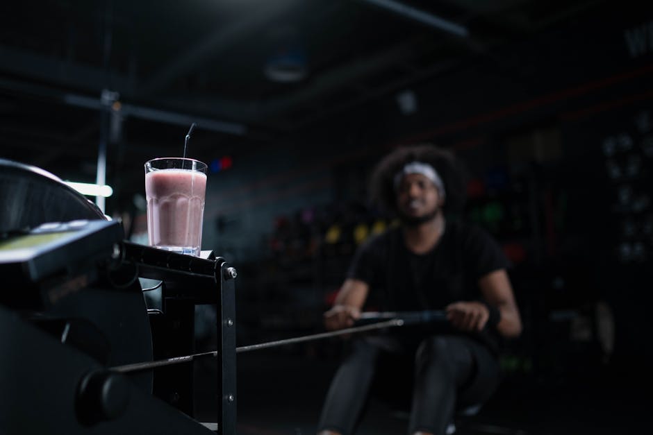 Smoothie Blender: 7 Things to Know Before You Buy Glass of strawberry smoothie on exercise machine, emphasizing fitness and refreshment in a gym setting.