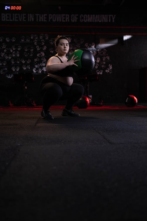 Woman in Black Sports Bra and Black Leggings Exercising