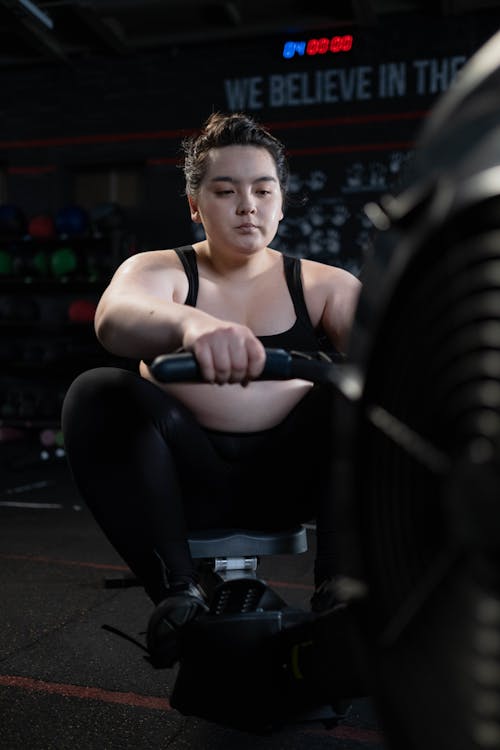 Woman in Black Sports Bra and Black Leggings Exercising