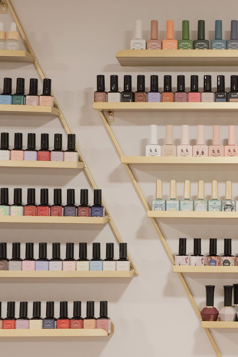 Esmaltes de uñas ordenados en estantes de madera