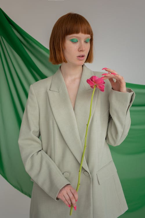 Stylish woman with flower in studio