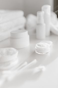 Elegant white skincare products arranged on a light background, showcasing purity and simplicity.