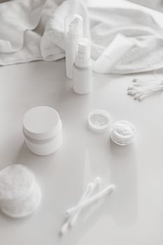 Elegant display of white skincare products with towel, ideal for clean beauty themes.