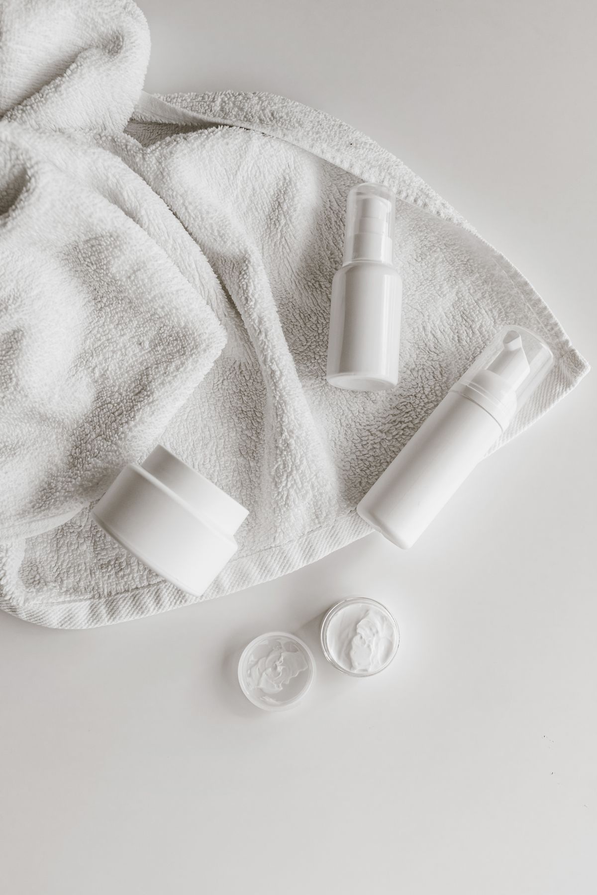 Skincare products arranged on a clean white towel