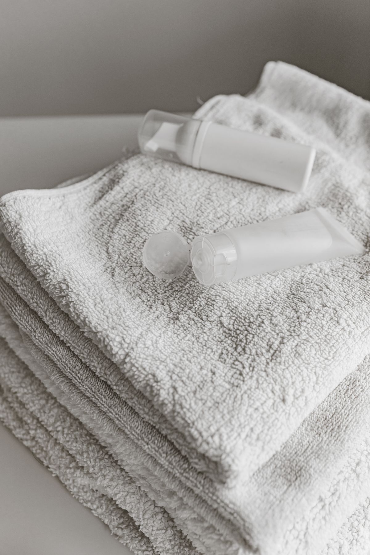 Beauty products arranged on white towels for bathroom cabinet organization ideas