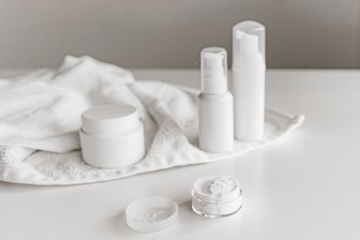 Elegant display of skincare products on a white surface, highlighting simplicity and purity.