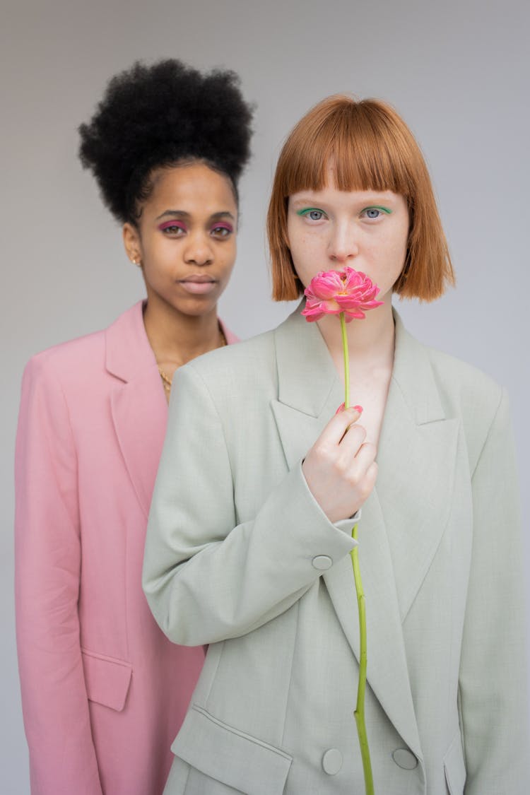 Woman Smelling Flower Near Black Model