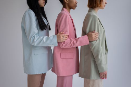 Free Side view of crop multiracial female models wearing trendy formal outfits standing in row against gray background Stock Photo