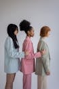 Multiracial women in light colored outfits in row