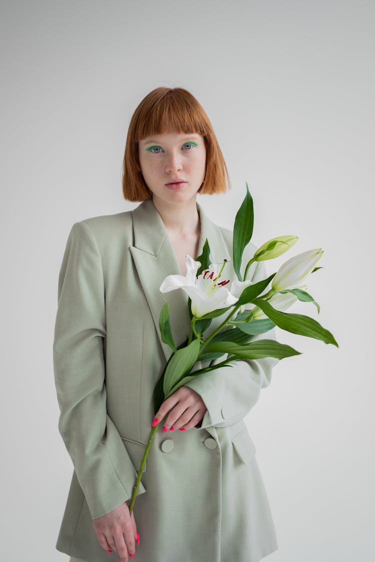 Serious Woman With Blooming Flower In Studio