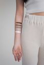 Crop unrecognizable female with painted colors on hand representing skin tones against gray background
