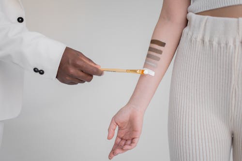 Black man painting stripes on hand of woman