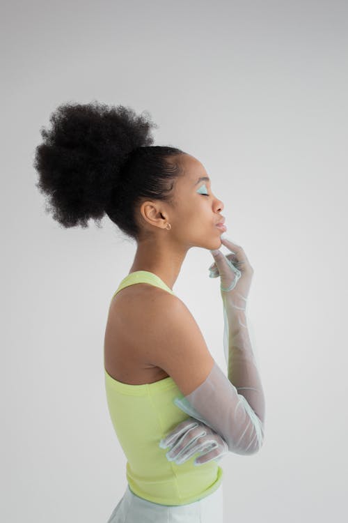 Black woman in gloves touching chin with finger