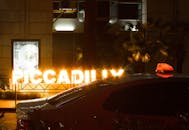 夜晚的城市街头，皮卡迪利标志亮着灯光，出租车穿梭其间