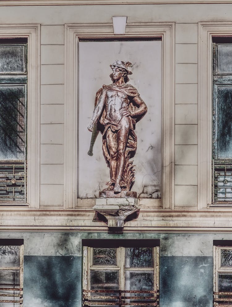 Bronze Sculpture Of Man On Building Wall