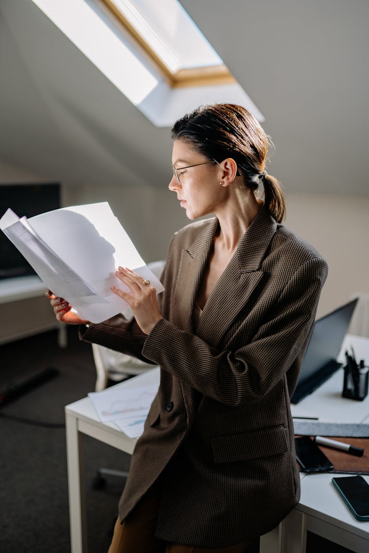 A Woman In Corporate Attire Reading Files