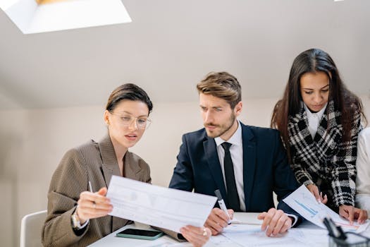 A group of employees reviewing documents in a modern office setting, fostering teamwork and collaboration.