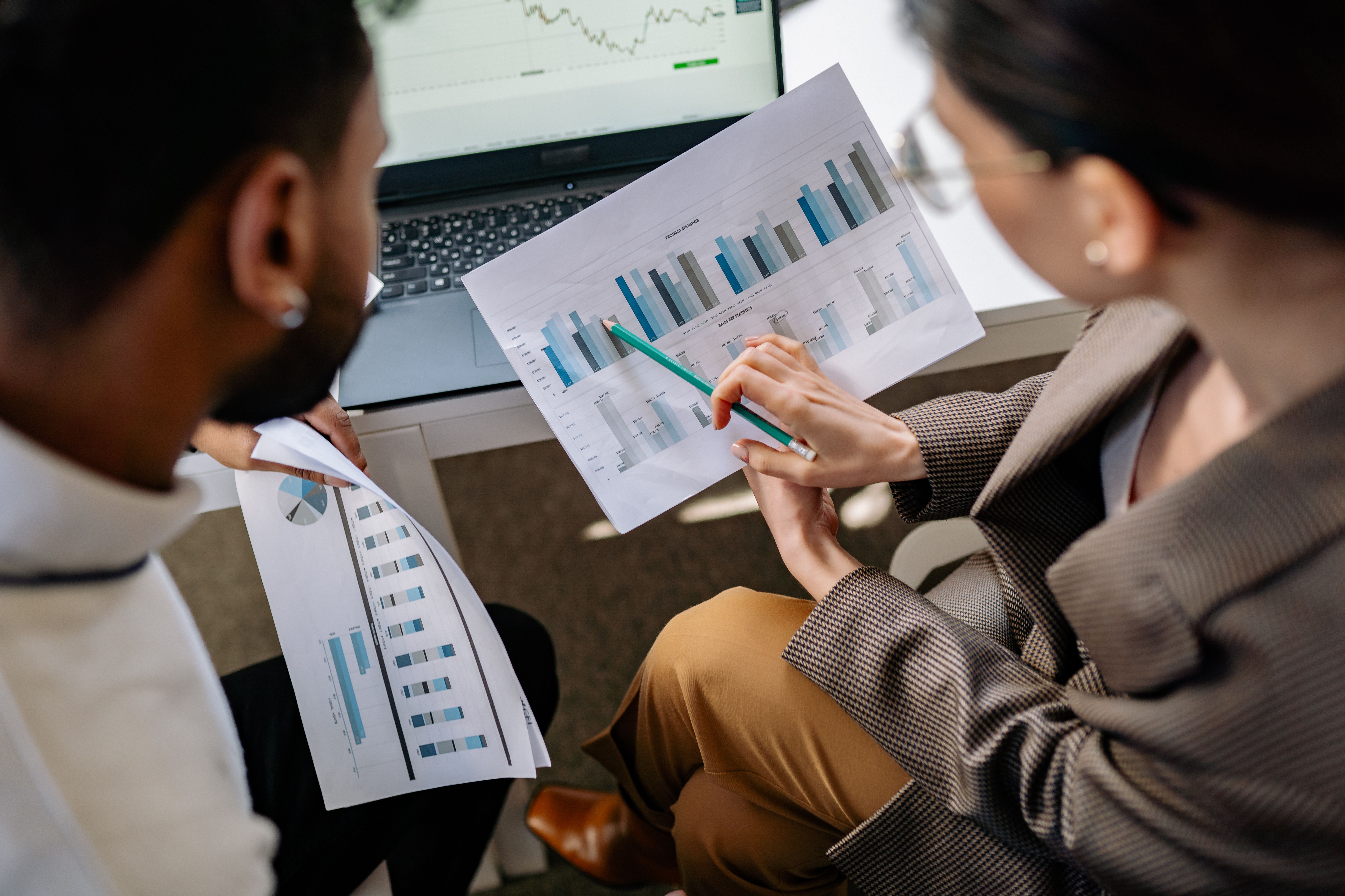 Two people discussing graphs on papers