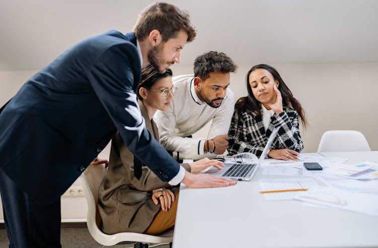 A Group Of People Looking At The Laptop