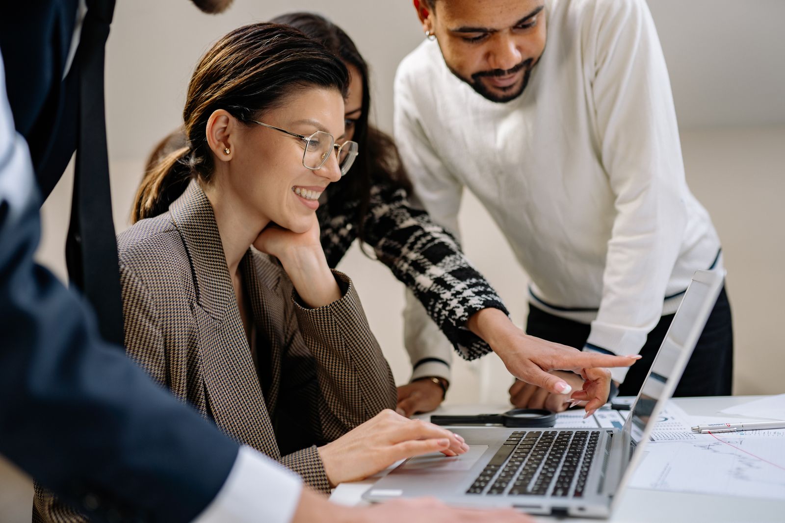 A smiling team working around a laptop