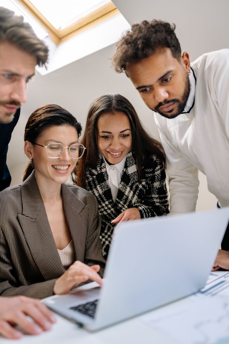 Colleagues smiling around a laptop — photo by Yan Krukau on Pexels